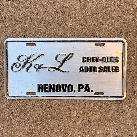 Photo of a 1990 Era Pennsylvania Dealer License Plate Booster License Plate Auto Tag Garage Decor Vintage Renovo Metal K & L Chevy Oldsmobile with original patina