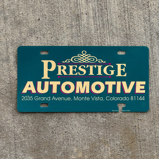 Photo of a 1990 Era Prestige Auto Monte Vista Colorado Booster License Plate Auto Tag Garage Decor Vintage Flimsy Plastic with original patina