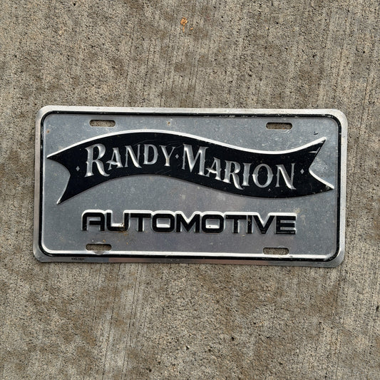 Photo of a 1990 Era Randy Marion Automotive Booster License Plate Auto Tag Garage Decor Vintage Metal with original patina