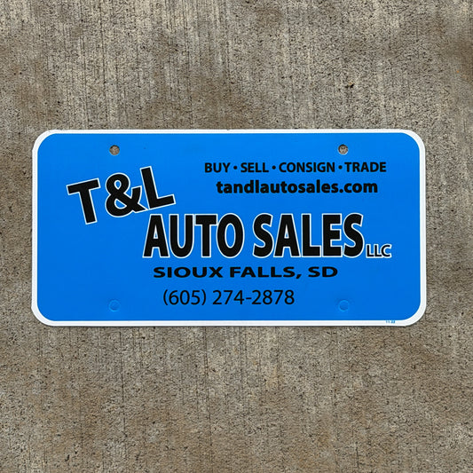 Photo of a 1990 Era Sioux Falls South Dakota Booster License Plate Auto Tag Garage Decor Vintage T & L Auto Sales Plastic with original patina