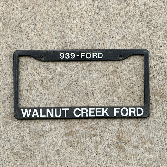 Photo of a 1990 Era Walnut Creek California Dealer License Plate Frame Auto Tag Garage Decor Vintage
 Plastic Ford with original patina
