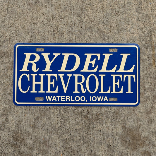 Photo of a 1990 Era Waterloo Iowa Booster License Plate Auto Tag Garage Decor Vintage Rydell Chevy Plastic with original patina