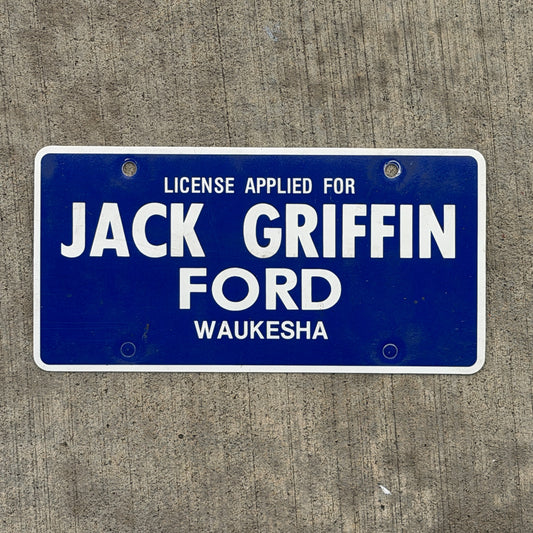 Photo of a 1990 Era Waukesha Wisconsin Booster License Plate Auto Tag Garage Decor Vintage Jack Griffin Ford Plastic with original patina