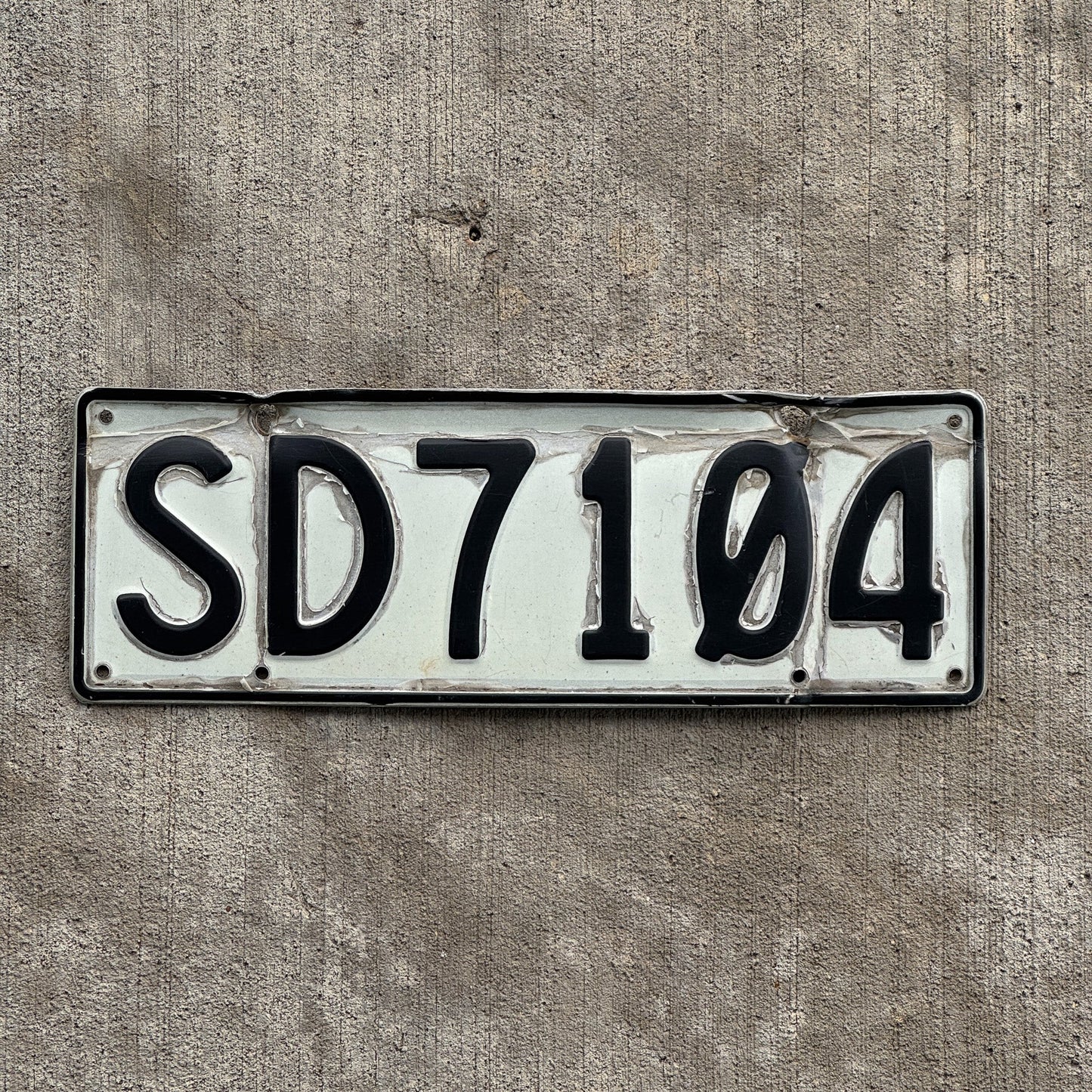 Photo of a 1990 New Zealand License Plate Auto Tag Garage Decor Vintage Stratford County SD 7104 with original patina