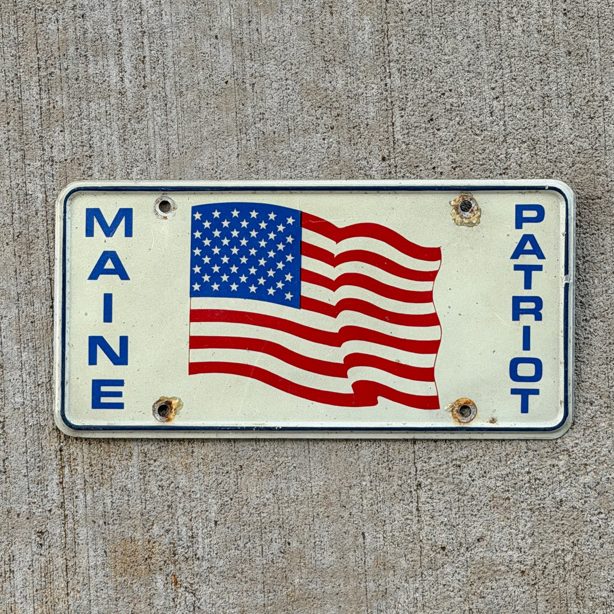 Photo of a 1991 Maine Patriot Booster License Plate Auto Tag Garage Decor Vintage
 Gulf War Veteran with original patina