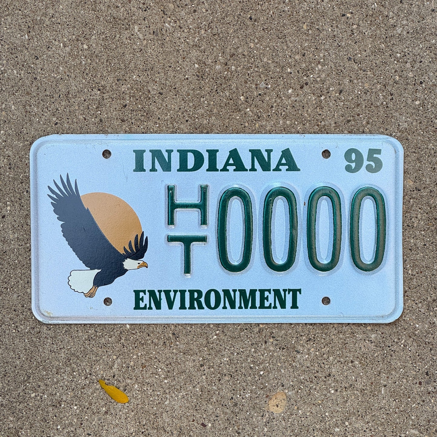 Photo of a 1994 1995 Indiana Graphic Sample License Plate Auto Tag Garage Decor Vintage Environment Bald Eagle HT 0000 with original patina