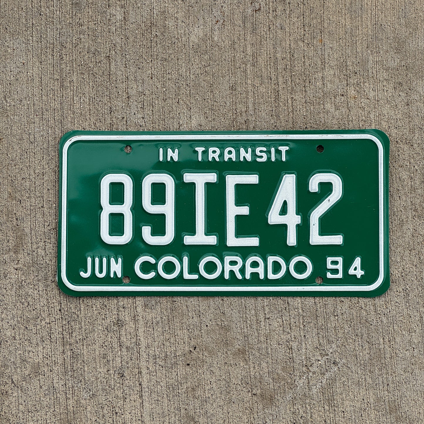 Photo of a 1994 Colorado In Transit Dealer License Plate Auto Tag Garage Decor Vintage 89 IE 42 with original patina