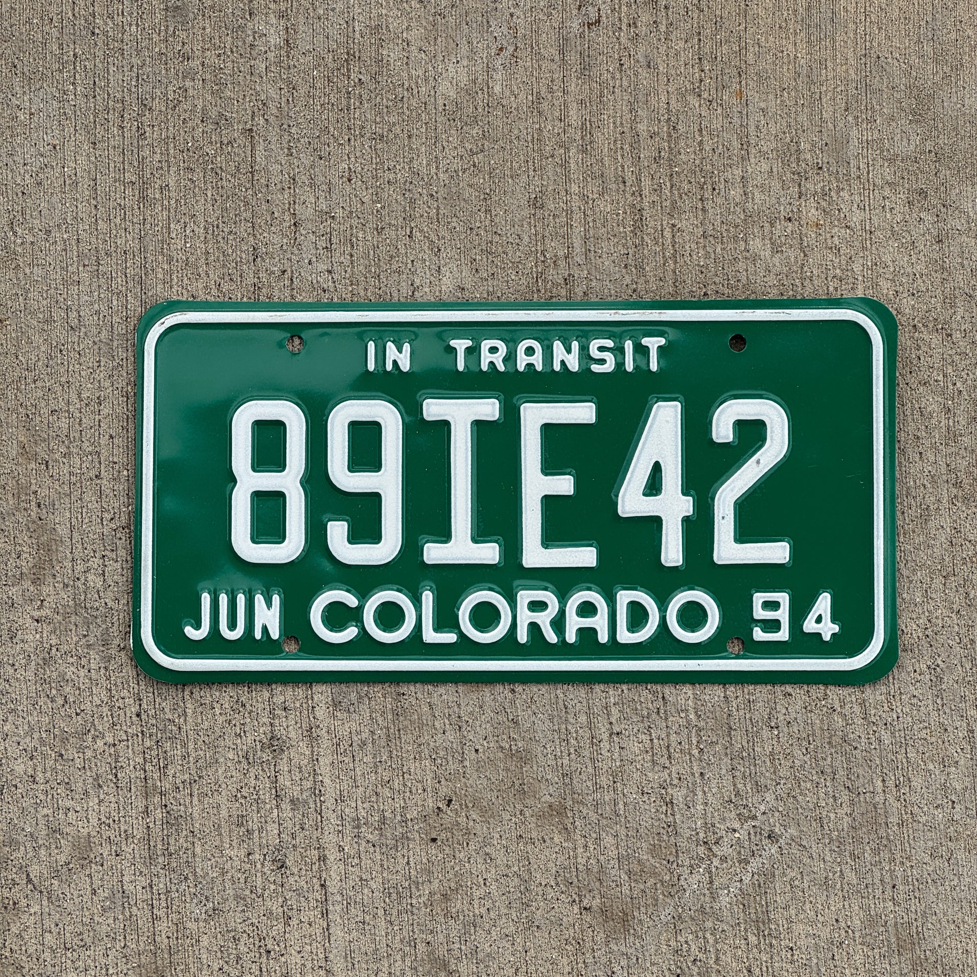 Photo of a 1994 Colorado In Transit Dealer License Plate Auto Tag Garage Decor Vintage 89 IE 42 with original patina