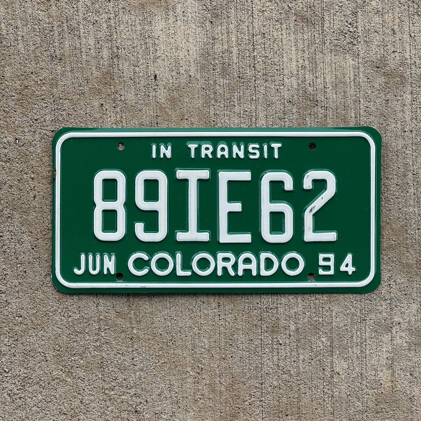 Photo of a 1994 Colorado In Transit Dealer License Plate Auto Tag Garage Decor Vintage 89 IE 62 with original patina
