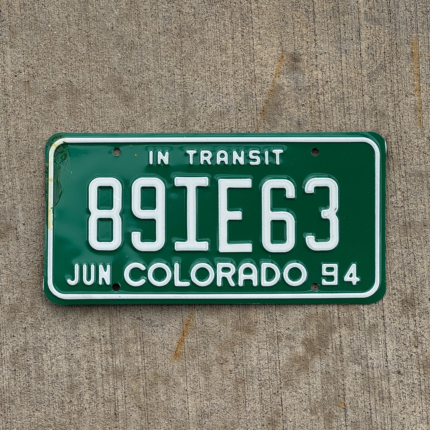 Photo of a 1994 Colorado In Transit Dealer License Plate Auto Tag Garage Decor Vintage 89 IE 63 with original patina