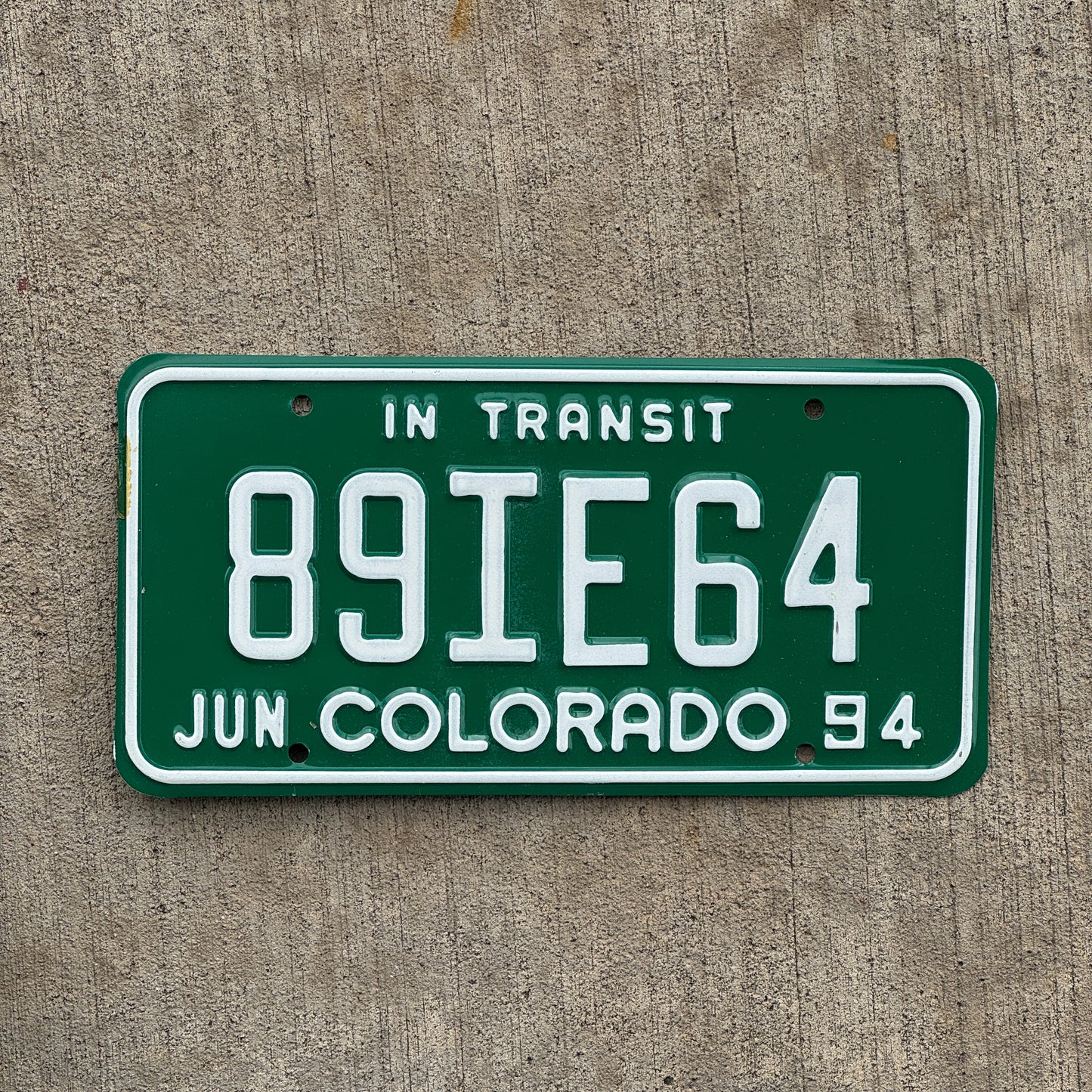 Photo of a 1994 Colorado In Transit Dealer License Plate Auto Tag Garage Decor Vintage 89 IE 64 with original patina