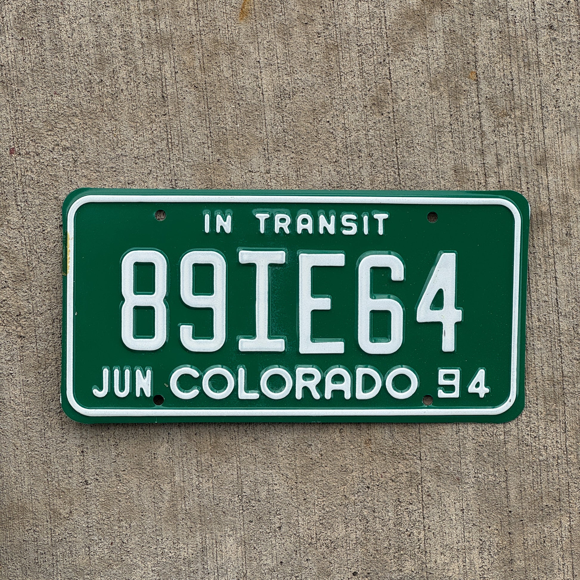 Photo of a 1994 Colorado In Transit Dealer License Plate Auto Tag Garage Decor Vintage 89 IE 64 with original patina