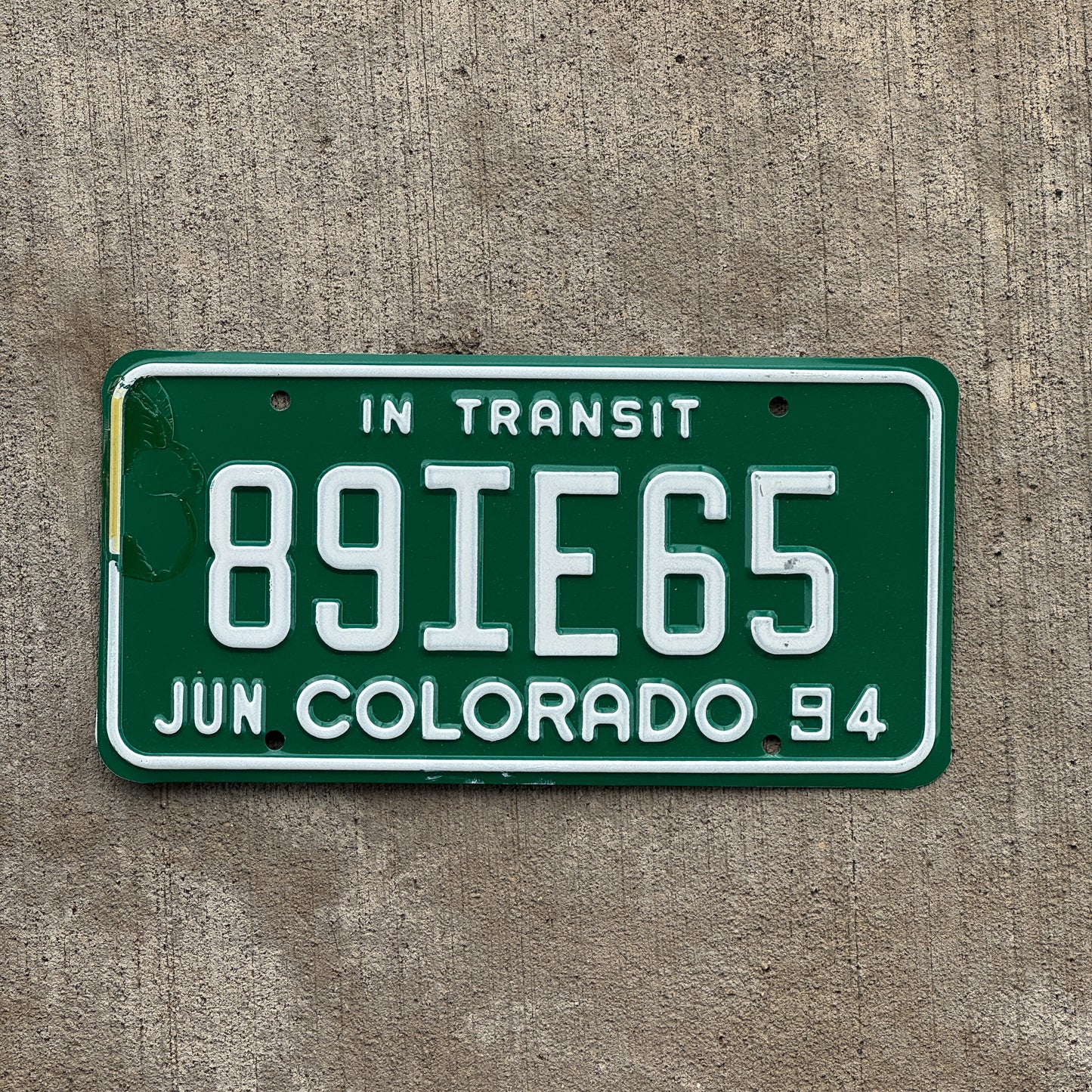 Photo of a 1994 Colorado In Transit Dealer License Plate Auto Tag Garage Decor Vintage 89 IE 65 with original patina