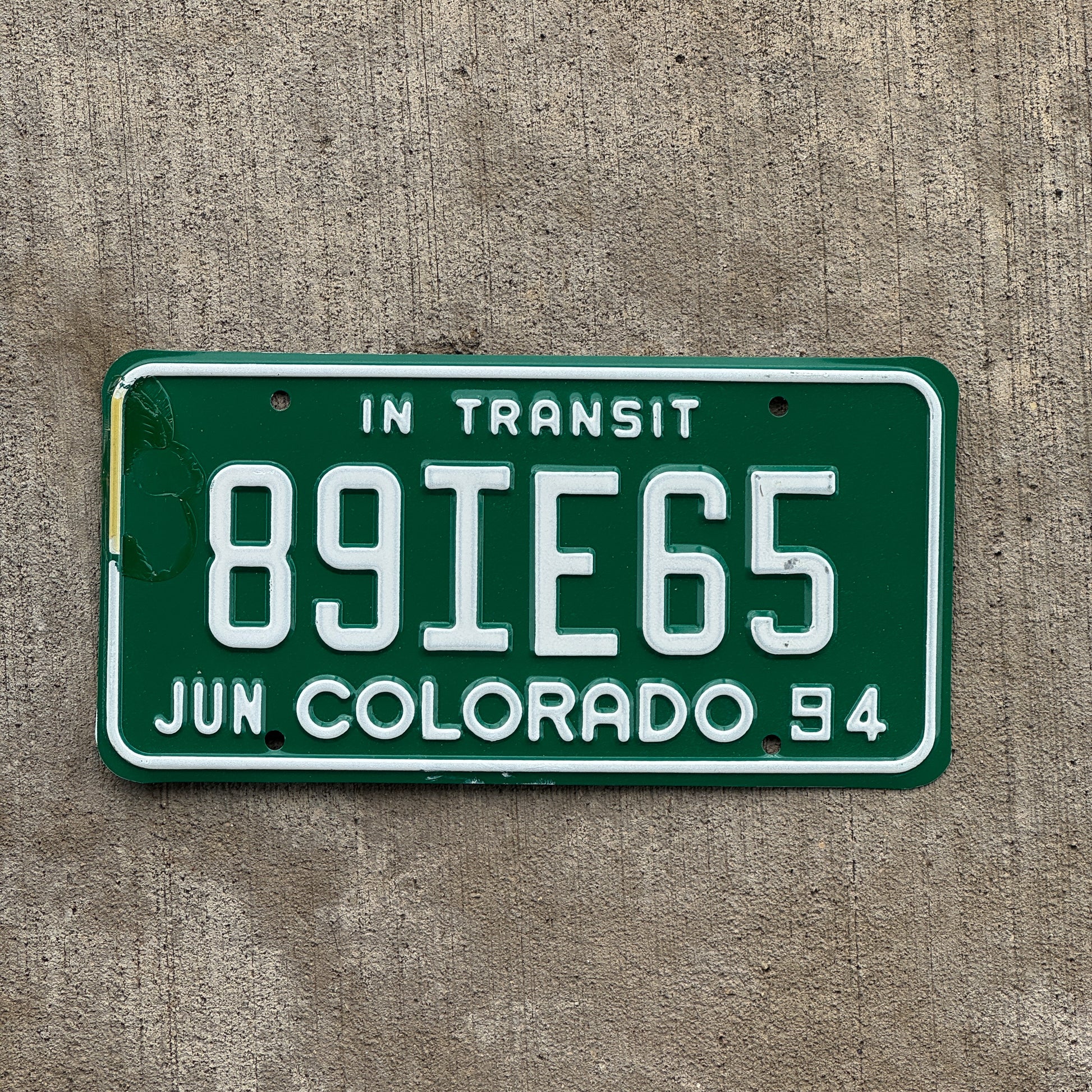 Photo of a 1994 Colorado In Transit Dealer License Plate Auto Tag Garage Decor Vintage 89 IE 65 with original patina