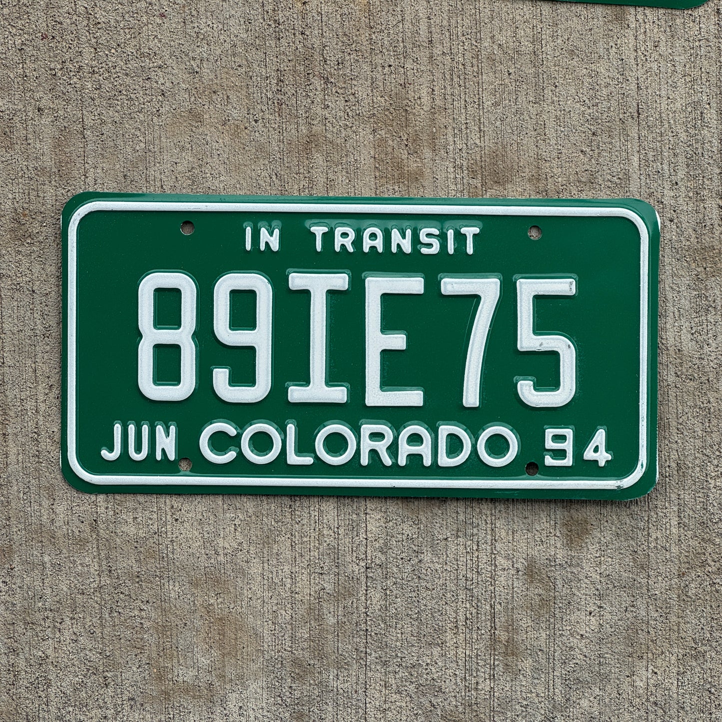 Photo of a 1994 Colorado In Transit Dealer License Plate Auto Tag Garage Decor Vintage 89 IE 75 with original patina