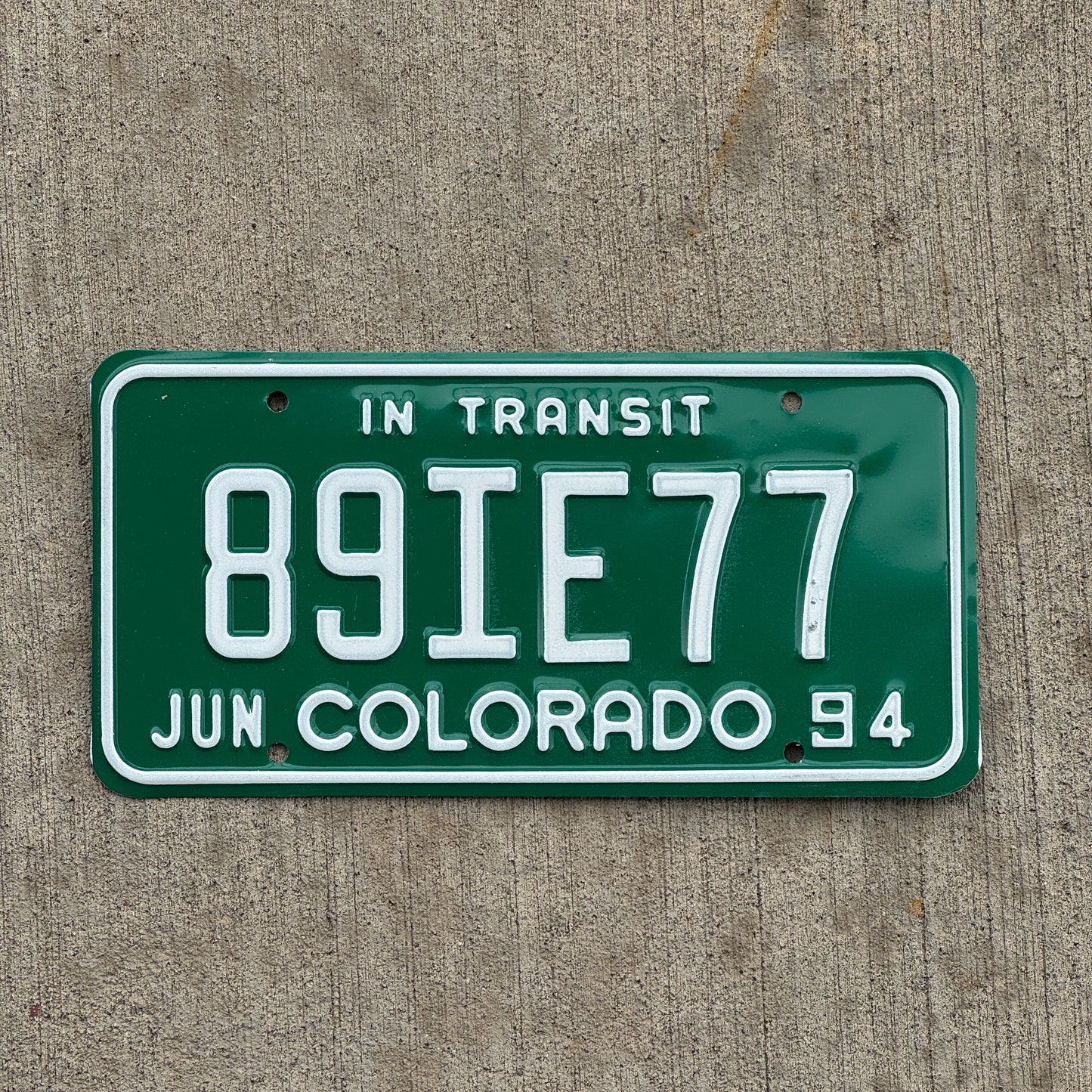 Photo of a 1994 Colorado In Transit Dealer License Plate Auto Tag Garage Decor Vintage 89 IE 77 with original patina