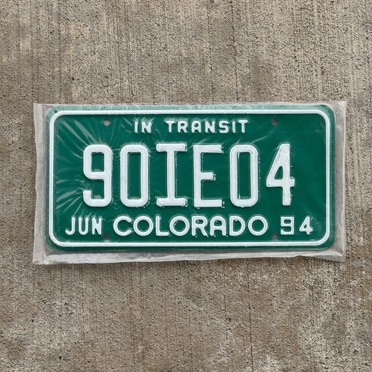 Photo of a 1994 Colorado In Transit Dealer License Plate Auto Tag Garage Decor Vintage New Old Stock NOS 90 IE 04 with original patina