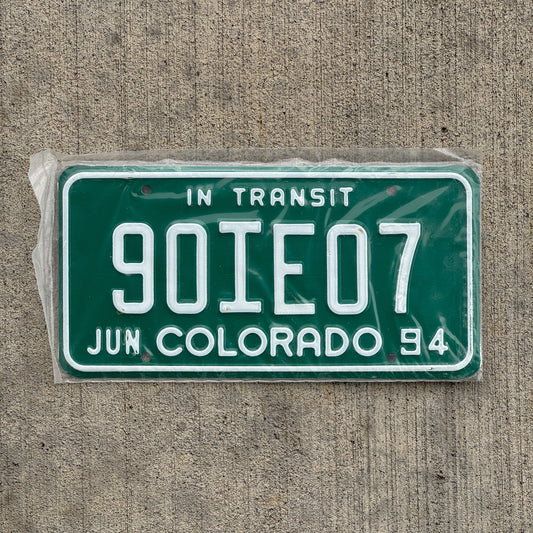 Photo of a 1994 Colorado In Transit Dealer License Plate Auto Tag Garage Decor Vintage New Old Stock NOS 90 IE 07 with original patina