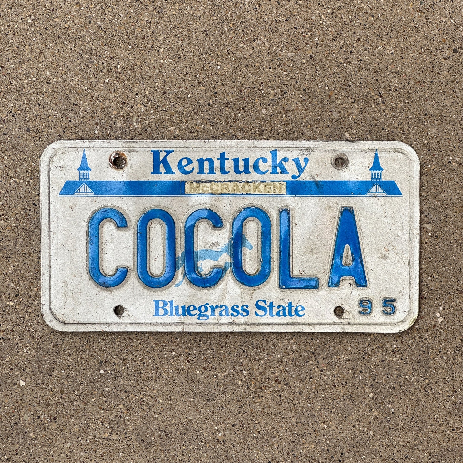 Photo of a 1995 Kentucky Vanity License Plate Auto Tag Garage Decor Vintage Coke Cola COCOLA