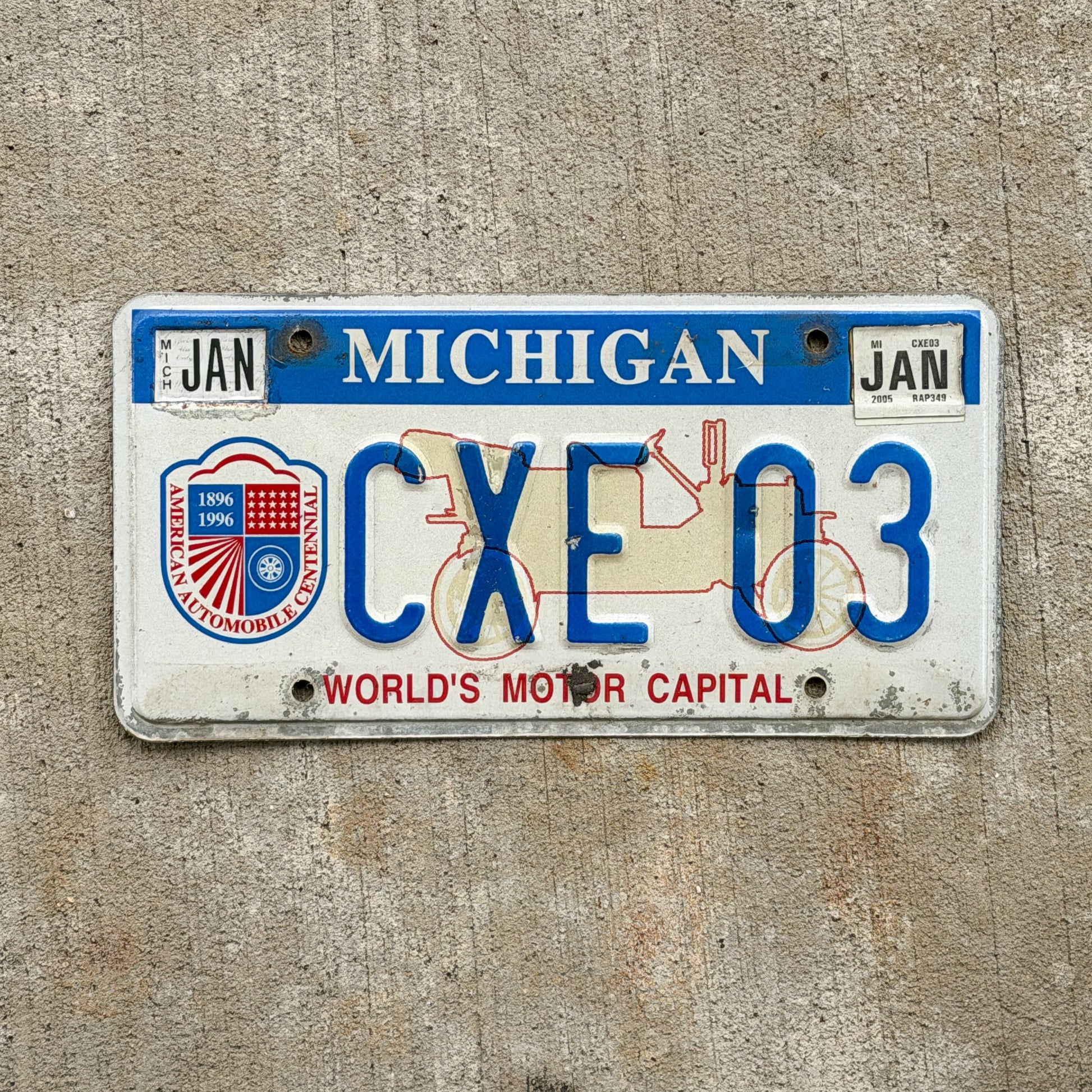 Photo of a 1996 2005 Michigan Graphic / Specialty License Plate Auto Tag Garage Decor Vintage World's Motor Capital CXE 03 with original patina