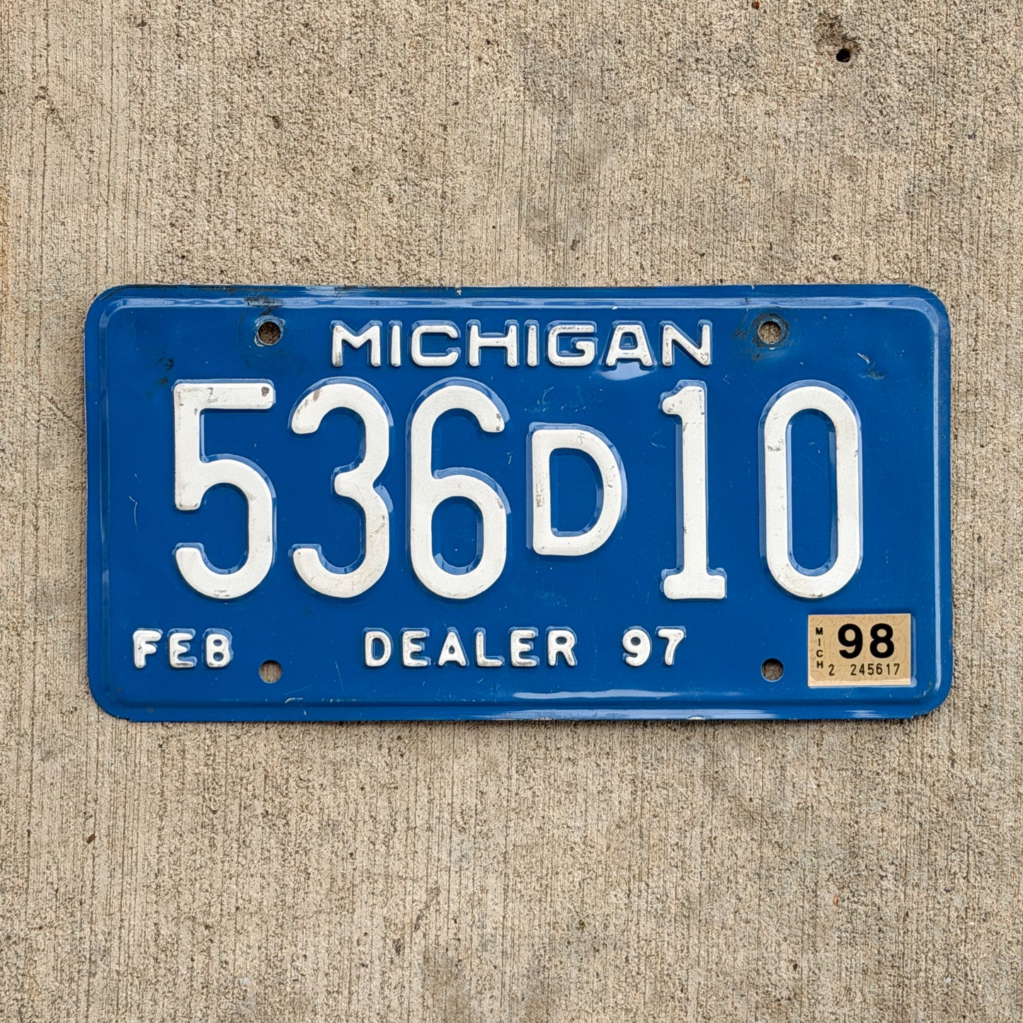 Photo of a 1997 1998 Michigan Dealer License Plate Auto Tag Garage Decor Vintage 536 D 10 with original patina