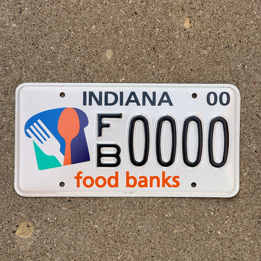 Photo of a 1999 2000 Indiana Graphic Sample License Plate Auto Tag Garage Decor Vintage Food Banks FB 0000 with original patina