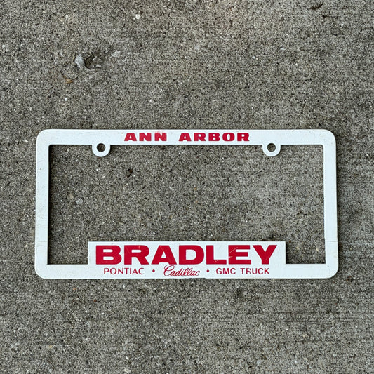 Photo of a 2000 Era Ann Arbor Michigan License Plate Frame Auto Tag Garage Decor Vintage
 Bradley Pontiac Cadillac GMC Truck Plastic with original patina