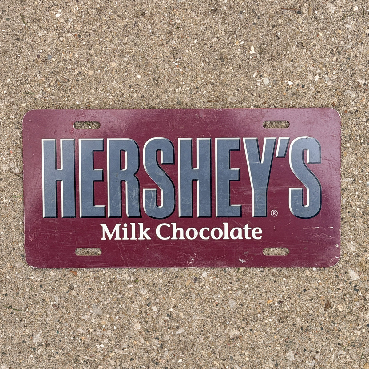 Photo of a 2000 Era Booster License Plate Auto Tag Garage Decor Vintage Hershey's Milk Chocolate Metal with original patina