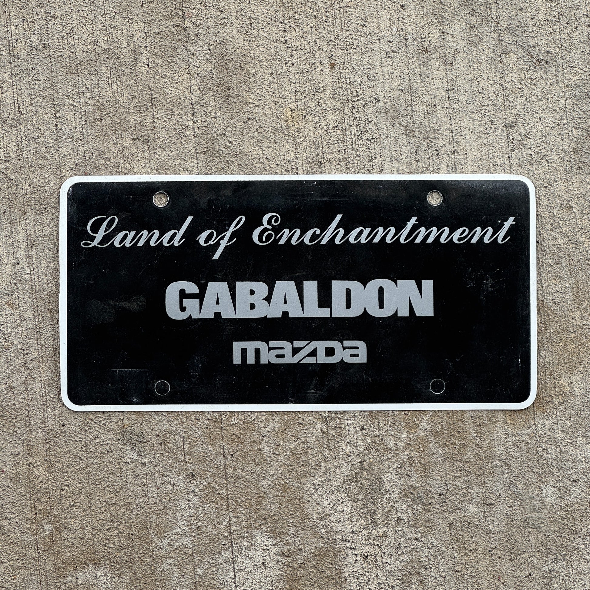 Photo of a 2000 Era Gabaldon Mzada New Mexico Booster License Plate Auto Tag Garage Decor Vintage Flimsy Plastic with original patina
