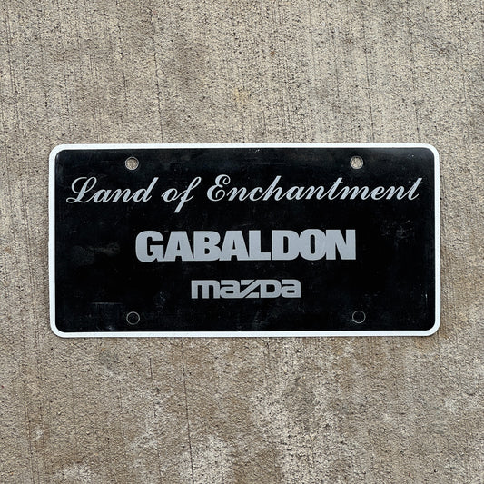 Photo of a 2000 Era Gabaldon Mzada New Mexico Booster License Plate Auto Tag Garage Decor Vintage Flimsy Plastic with original patina
