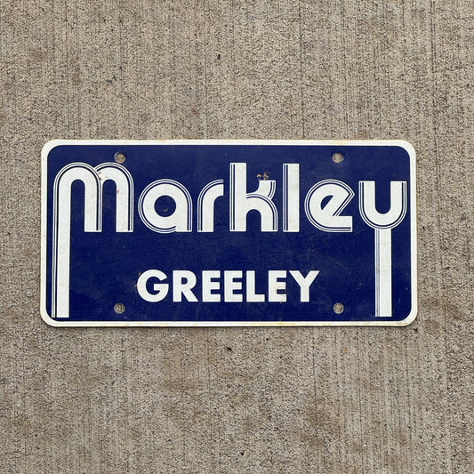 Photo of a 2000 Era Markley Greely Colorado Booster License Plate Auto Tag Garage Decor Vintage Flimsy Plastic with original patina