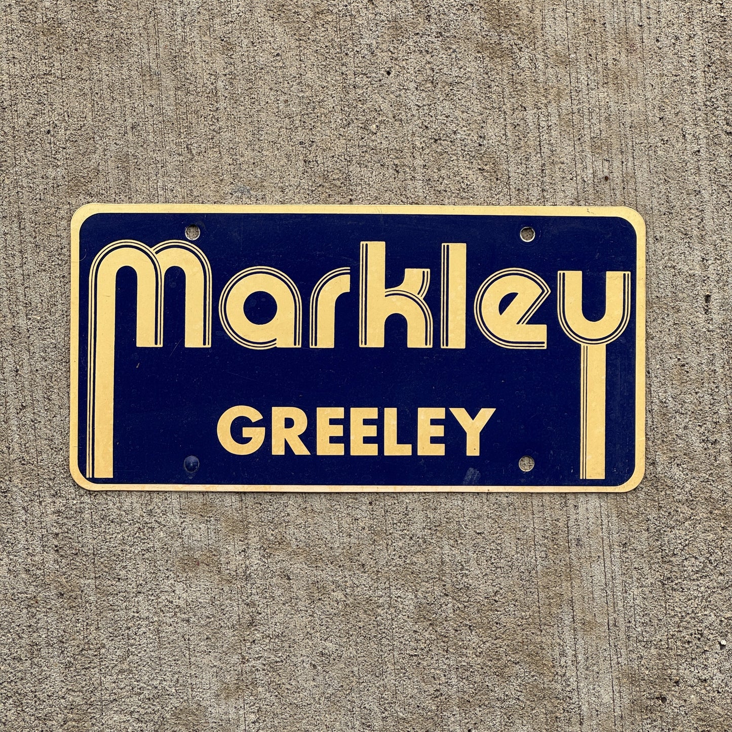 Photo of a 2000 Era Markley Greely Colorado Booster License Plate Auto Tag Garage Decor Vintage Flimsy Plastic with original patina