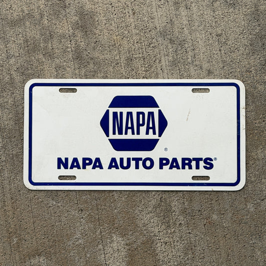 Photo of a 2000 Era Napa Auto Parts Booster License Plate Auto Tag Garage Decor Vintage Plastic with original patina