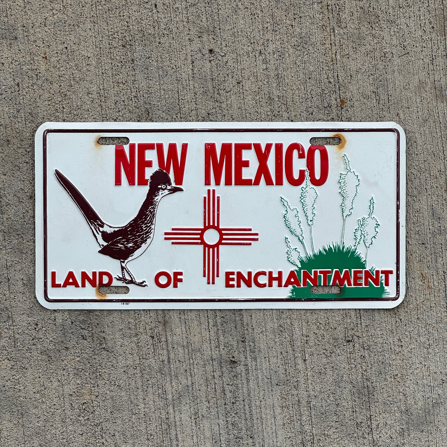 Photo of a 2000 Era New Mexico Booster License Plate Auto Tag Garage Decor Vintage Roadrunner Zia Metal with original patina