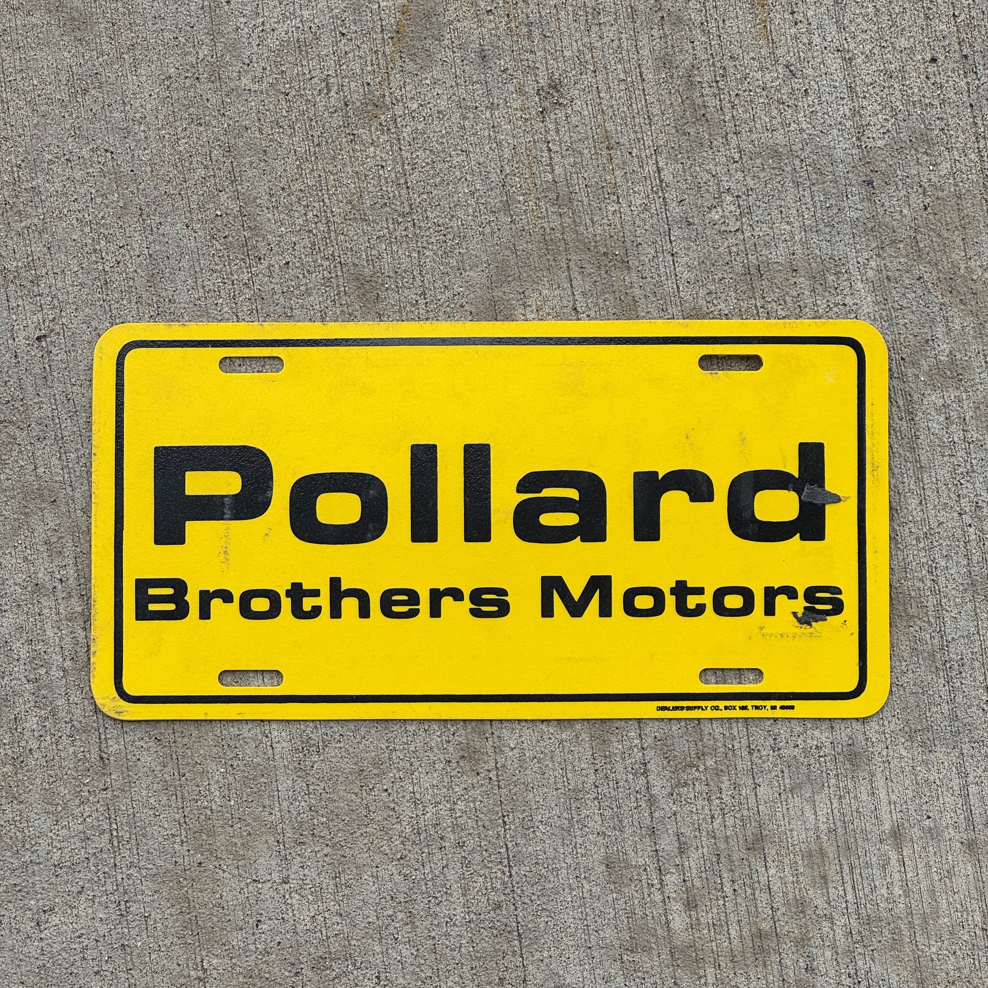 Photo of a 2000 Era Pollard Brothers Motors Montrose Colorado Booster License Plate Auto Tag Garage Decor Vintage Plastic with original patina