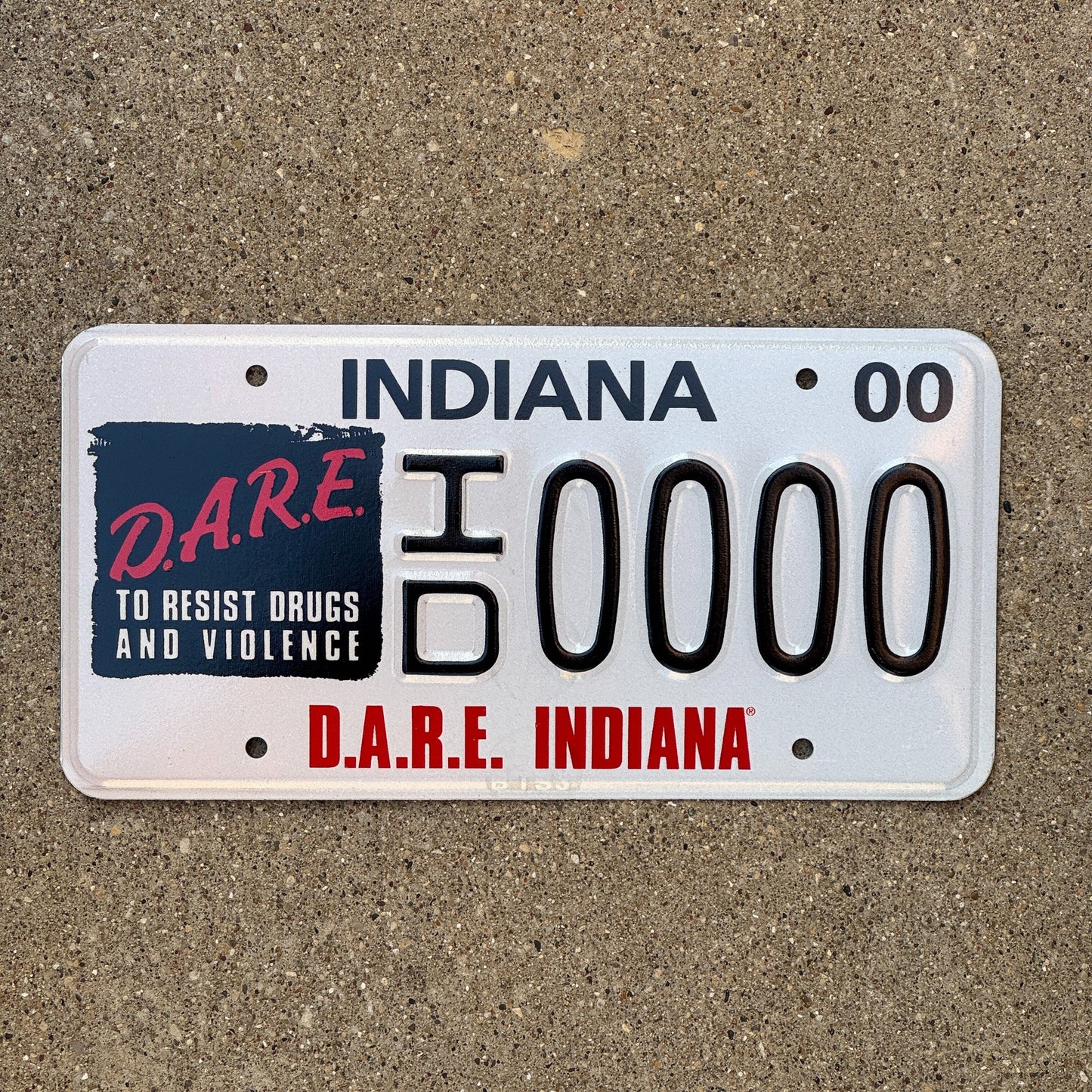 Photo of a 2000 Indiana Graphic Sample License Plate Auto Tag Garage Decor Vintage DARE ID 0000 with original patina