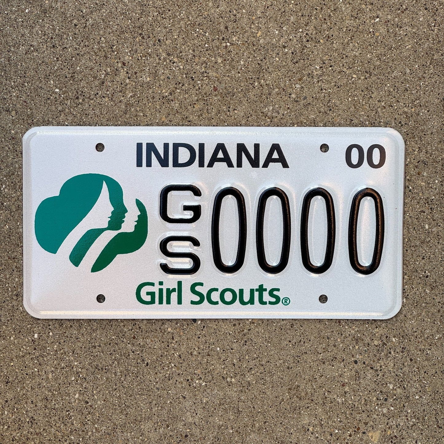 Photo of a 2000 Indiana Graphic Sample License Plate Auto Tag Garage Decor Vintage Girl Scouts of America GS 0000 with original patina