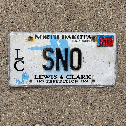 Photo of a 2001 2013 North Dakota Graphic Vanity License Plate Auto Tag Garage Decor Vintage Lewis and Clark Expedition "SNOW" SNO with original patina