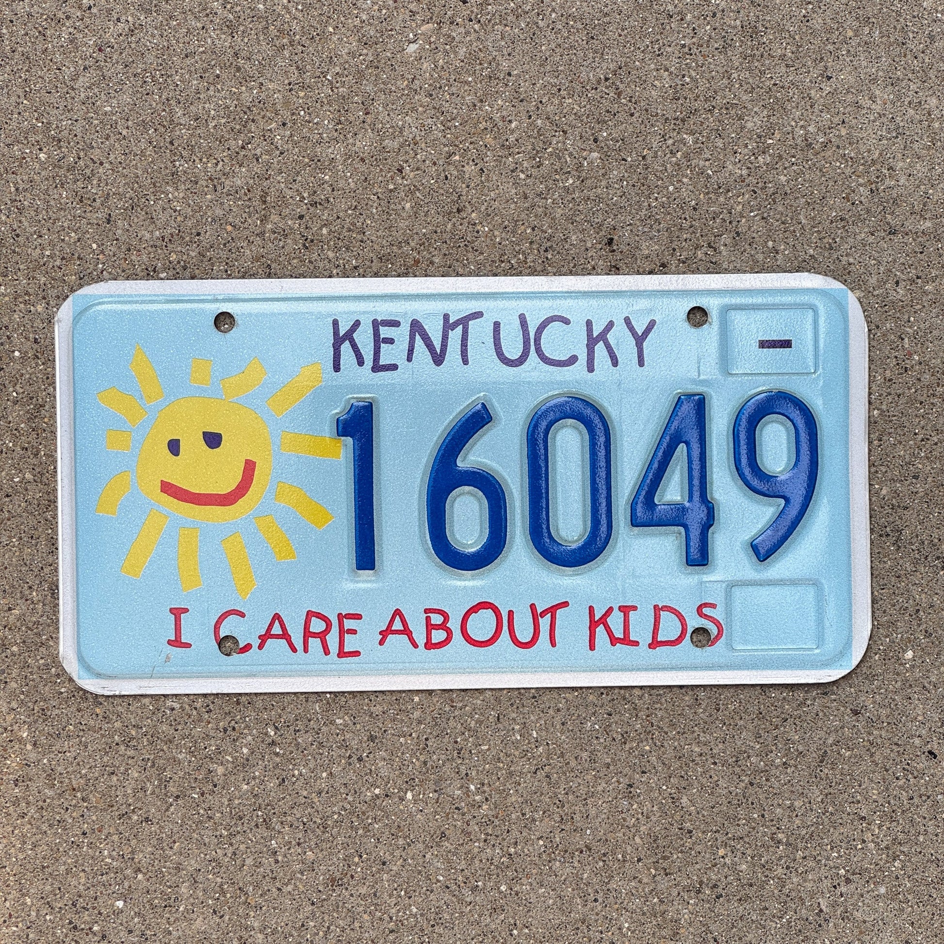 Photo of a 2003 Kentucky Graphic / Specialty License Plate Auto Tag Garage Decor Vintage I Care About Kids Children's Trust Fund 16049