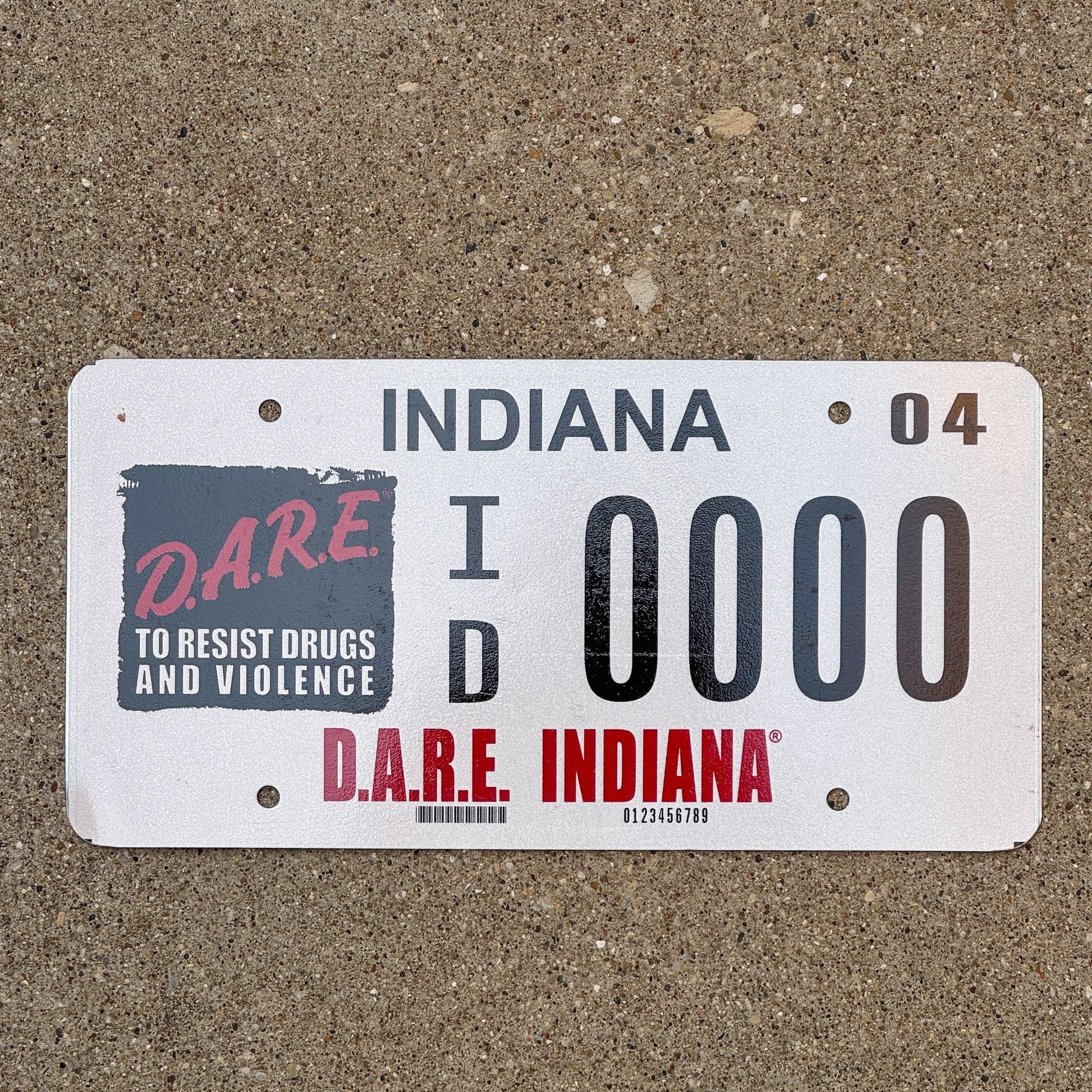 Photo of a 2004 Indiana Graphic Sample License Plate Auto Tag Garage Decor Vintage DARE ID 0000 with original patina