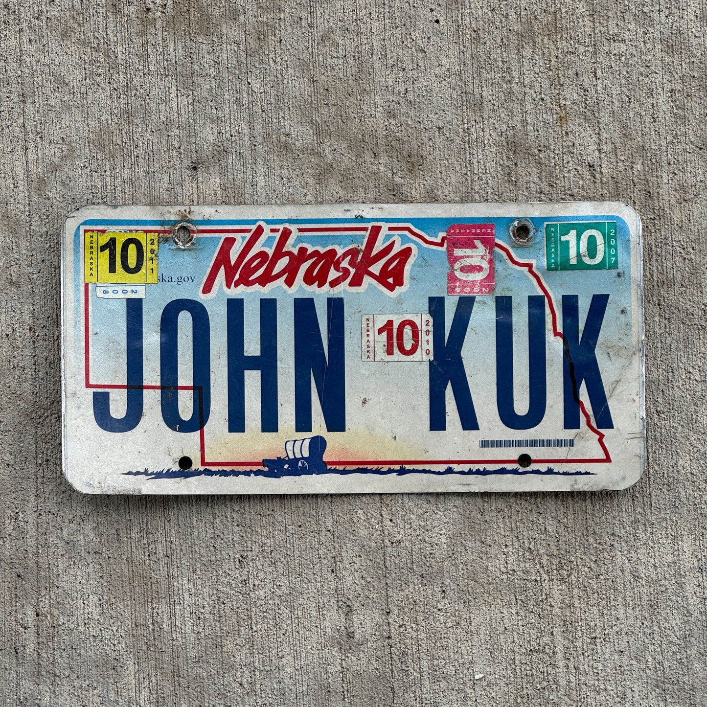 Photo of a 2005 2011 Nebraska Vanity License Plate Auto Tag Garage Decor Vintage Name JOHN KUK with original patina
