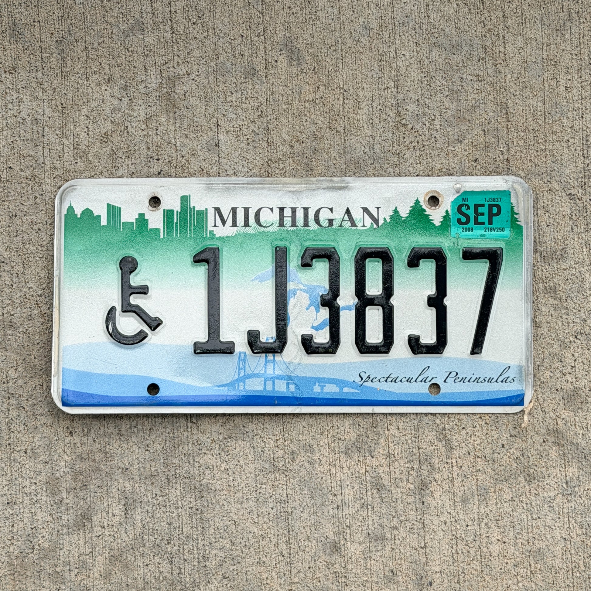 Photo of a 2007 2008 Michigan Graphic / Specialty License Plate Auto Tag Garage Decor Vintage Spectacular Peninsulas Handicap 1J3837 with original patina