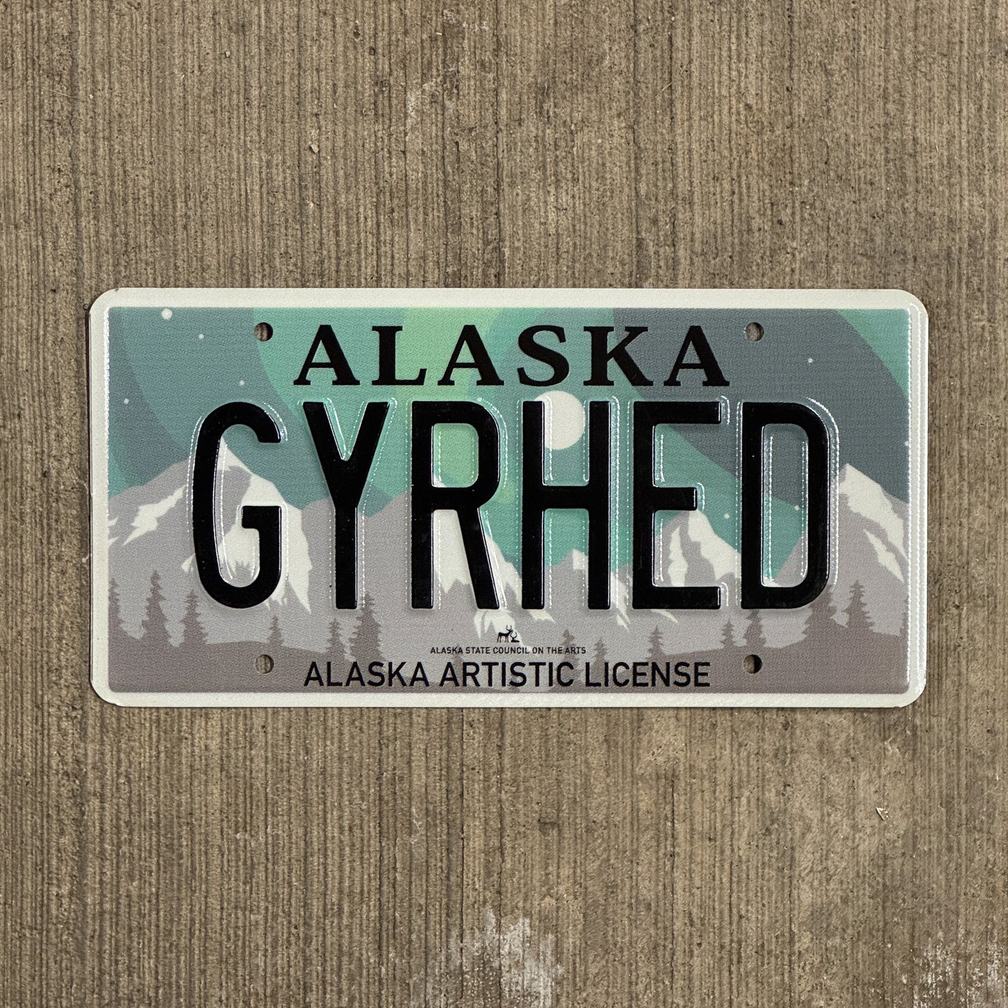 Photo of a 2019 Alaska Graphic Vanity License Plate Auto Tag 1 Vintage Garage Artistic Northern Lights Gear Head GYRHED with original patina