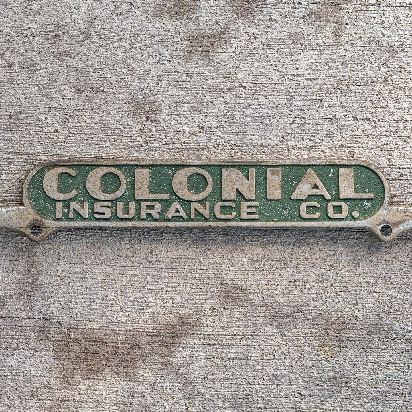 Detail view of the Colonial Insurance Co writing on the license plate frame.