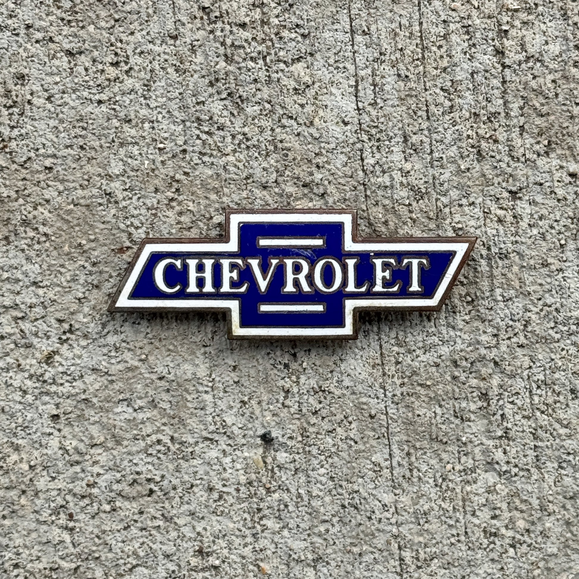 Photo of a Chevy Bowtie Porcelain Badge Emblem License Plate Topper Auto Tag Garage Decor Vintage Chevrolet with original patina